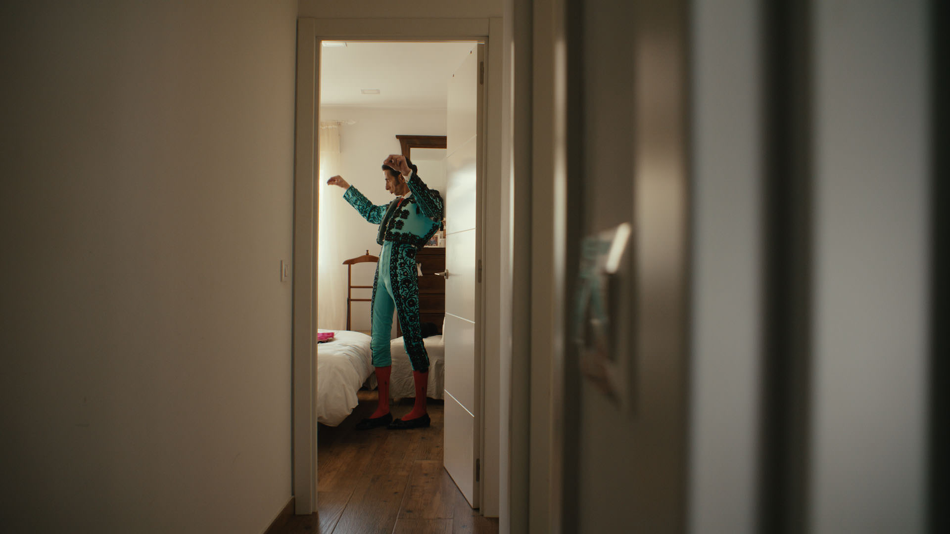 A bullfighter getting dressed in a quiet bedroom